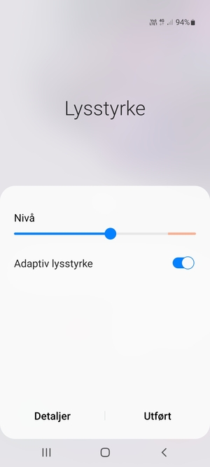 Slå på Adaptiv lysstyrke og velg Utført