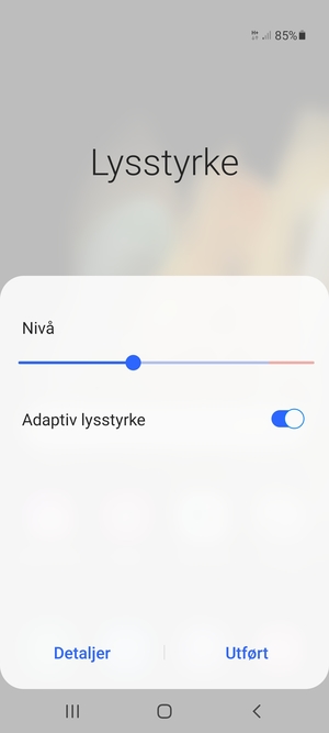 Slå på Adaptiv lysstyrke og velg Utført