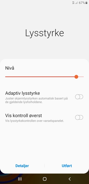 Slå på Adaptiv lysstyrke og velg Utført
