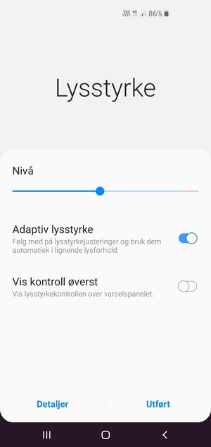Slå på Adaptiv lysstyrke og velg Utført