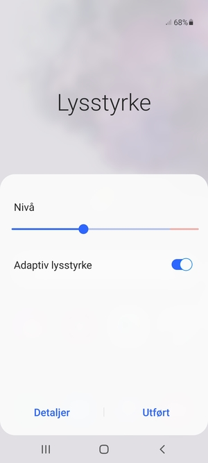 Slå på Adaptiv lysstyrke og velg Utført