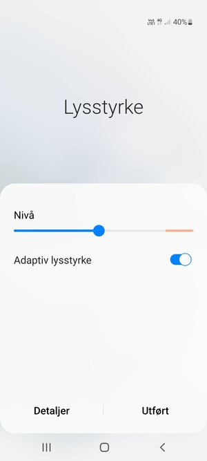 Slå på Adaptiv lysstyrke og velg Utført