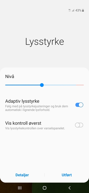 Slå på Adaptiv lysstyrke og velg Utført