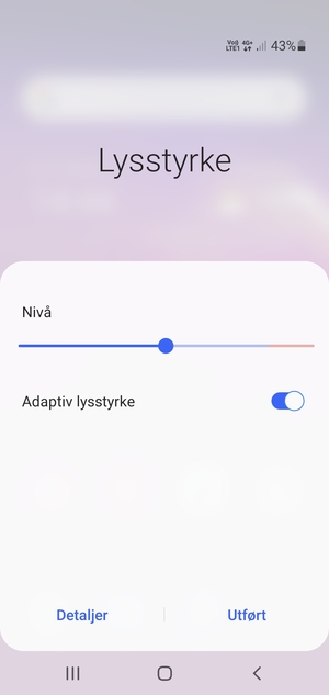 Slå på Adaptiv lysstyrke og velg Utført