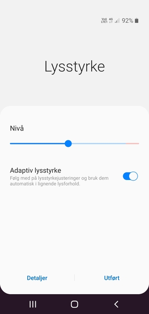Slå på Adaptiv lysstyrke og velg Utført